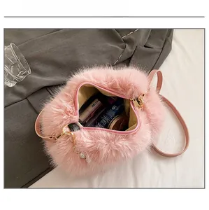 Internal capacity of pink plush shoulder bag showing makeup essentials and gold zipper