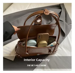 Detailed interior of brown leather pleated bag showing space for cosmetics and smartphone