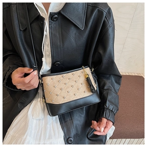 Detail of embroidered crossbody bag with diamond studs and stylish leather tassel charm