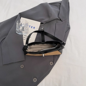 Top view of two-tone baguette bag with suede panel, silver zipper, and inner pocket