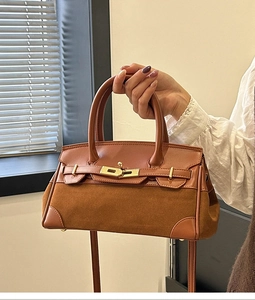 Détail du sac Kelly vintage en cuir marron avec fermoir métallique et panneaux en daim