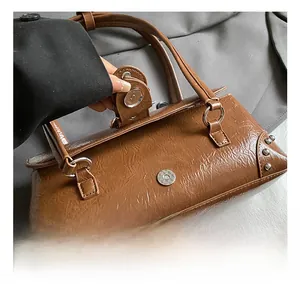 Detailed shot of brown vintage leather bag with silver rivets and magnetic closure