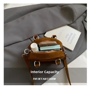 Internal storage view of brown suede mini bowling bag with daily essentials inside