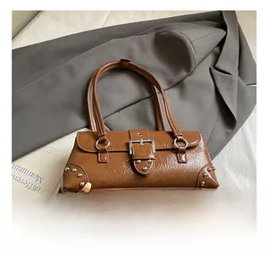 Detail of vintage brown baguette bag with glossy wrinkled leather and silver studs