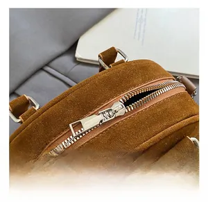 Close-up of silver zipper hardware and brown suede texture on vintage bowling bag