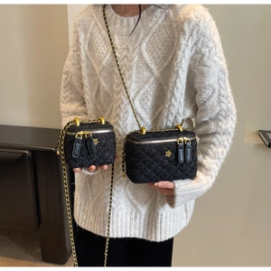 Détail de sacs boîtes en tweed avec texture matelassée et fermetures à fleurs dorées