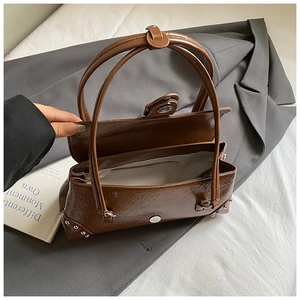 Detail view of brown faux leather handbag showing spacious interior and secure zipper pocket