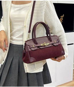 Détail d'un sac bandoulière bordeaux avec patchwork en daim et fermoir doré tournant