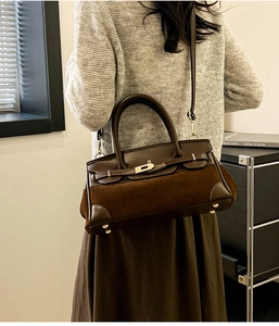 Détail des empiècements en cuir et daim marron foncé sur le sac à boucle classique
