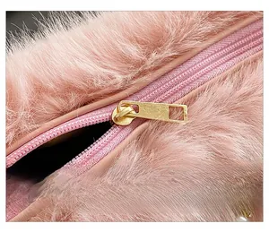 Detailed macro of smooth gold metal zipper and soft pink faux fur texture on lady handbag