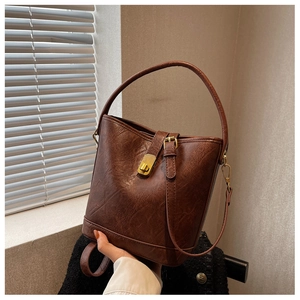 Détail du sac seau marron vintage avec cuir craquelé et fermoir doré rotatif