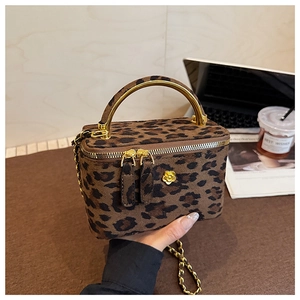 Gros plan du sac boîte à motif léopard avec fleurs dorées et double fermeture éclair