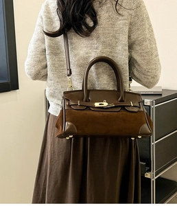 Détail du sac bandoulière en cuir marron foncé et daim montrant le fermoir et la texture