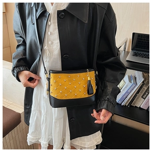 Detail of crossbody bag featuring ginger quilting and elegant black leather tassels