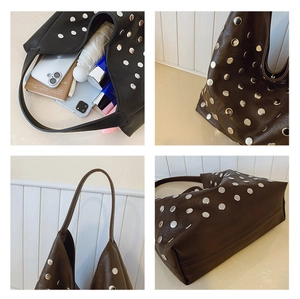 Detail view of large dark brown tote bag with silver rivet accents and spacious interior