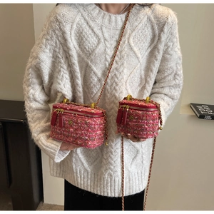 Detail of pink tweed crossbody bags with gold chain strap and floral metal buckle