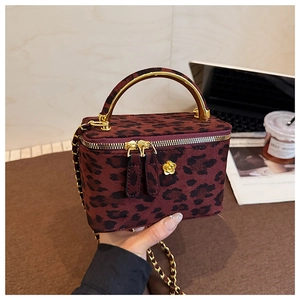 Détail du sac boîte léopard avec poignée dorée florale et bandoulière en chaîne