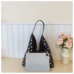 Detail showing spacious black rivet hobo bag next to a tablet for size comparison