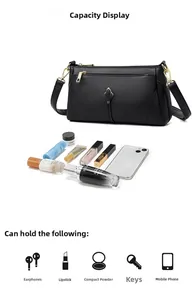 Detail of black pebbled leather crossbody bag with gold hardware and interior capacity