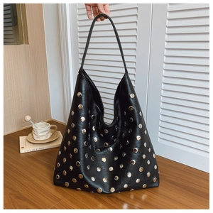 Detail of black Hobo bag with silver rivets on glossy leather for autumn fashion