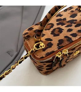 Détails du tissu léopard et de la poignée en métal doré de ce sac boîte sophistiqué
