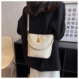 Détail du sac seau blanc crème avec cuir plissé élégant et fermoir doré raffiné