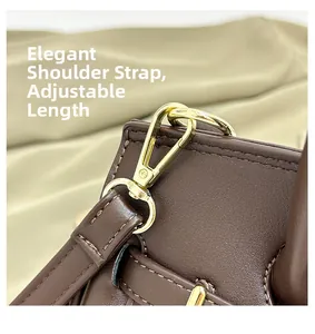 Détail de la bandoulière réglable avec garnitures métalliques dorées sur le sac en cuir