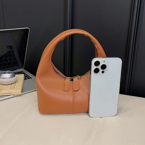 Comparaison de taille détaillée du sac à main en cuir marron avec un smartphone