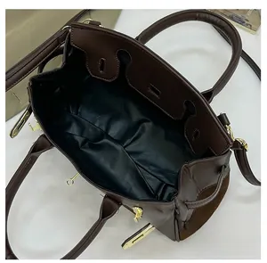 Vue de dessus de l'intérieur noir spacieux d'un sac marron mat avec boucles dorées