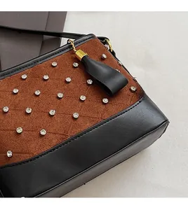 Close-up of quilted rhombic pattern with rhinestone studs and leather fringe detail