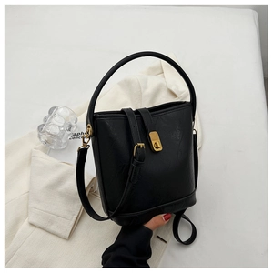 Détail du sac seau noir en cuir texturé litchi avec fermoir en métal doré chic