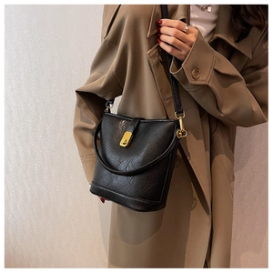 Vue détaillée du sac seau noir en cuir vintage avec fermoir doré et bandoulière longue