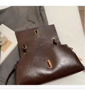 Detailed close-up of dark brown vintage faux leather texture and golden metal twist lock