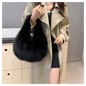 Close-up of fluffy black faux fur handbag held by model wearing a khaki trench coat
