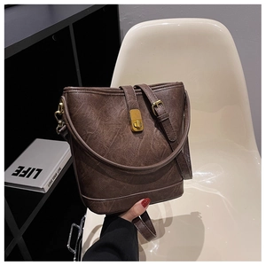 Détail du sac seau marron vintage avec texture en cuir craquelé et fermoir doré rotatif