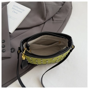 Detailed view of green quilted bag with rhinestone accents and interior zipper pocket