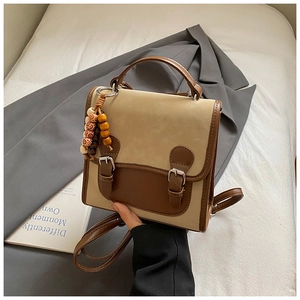 Dettaglio della borsa vintage bicolore con fibbie in bronzo e ciondolo etnico