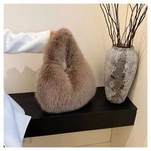 Detail of soft faux fur handbag in camel brown with elegant single handle design