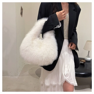 Close-up of fluffy white faux fur shoulder bag with soft plush texture on black outfit