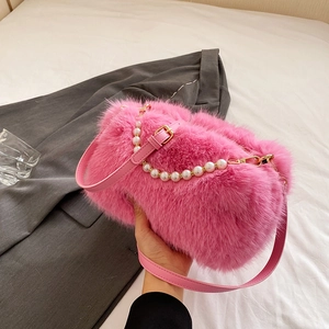 Pink faux fur shoulder bag with pearl chain and adjustable strap, hand-held shot