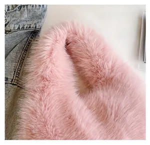 Close-up of soft pink faux fur texture and comfortable handle design of the plush handbag
