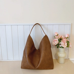 Minimalist brown leather hobo shoulder bag with textured finish and wide strap