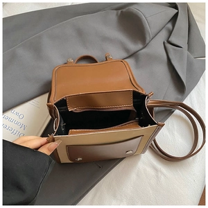 Dettaglio dell'interno di una piccola borsa bicolore con tasca zip e chiusura a scatto magnetico