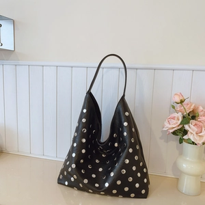 Retro black leather Hobo bag with silver rivets and wide strap shown with pink roses
