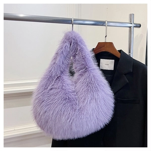 Detail shot of fluffy purple faux fur hobo handbag hanging on a metal rack