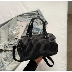 Dettaglio della borsa a scacchi con doppi manici e tracolla in nylon in scena lifestyle