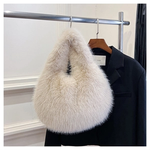 Detail view of plush faux fur texture on beige underarm bag hanging on a hanger