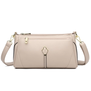 Elegant beige pebbled leather crossbody bag for women with golden floral metal accent
