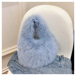 Close-up of fluffy ice blue faux fur handbag with a soft plush texture on a white chair