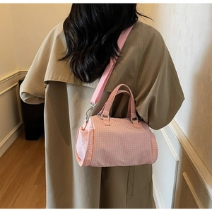 Dettaglio della borsa a scacchi rosa indossata con trench kaki, vista posteriore